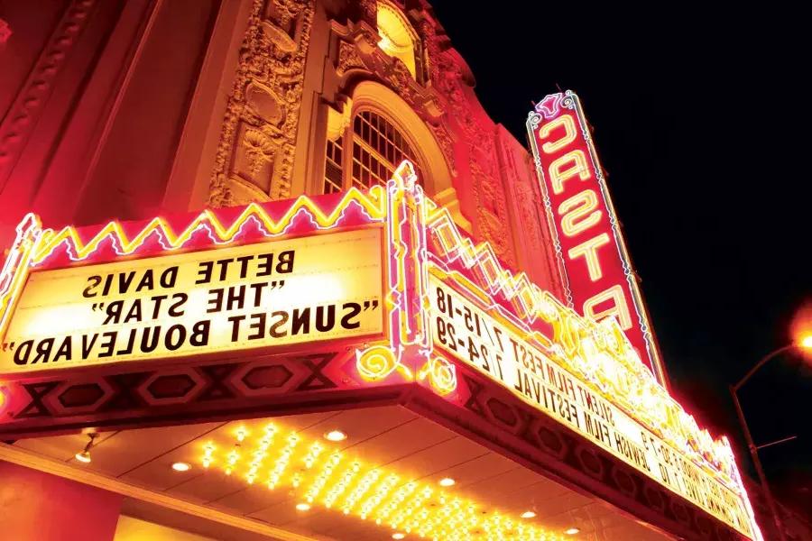 La marquesina de neón y el cartel del Teatro Castro se iluminan por la noche.